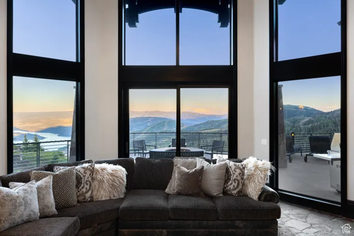 Living area featuring a towering ceiling, a mountain view, and healthy amount of natural light
