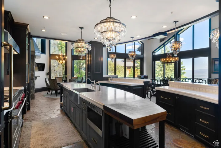 Kitchen featuring dark cabinets, stone tile floors, appliances with stainless steel finishes, healthy amount of natural light, and recessed lighting