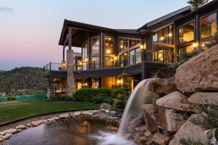 Back of house featuring a garden pond, a yard, a wooden deck, and a patio