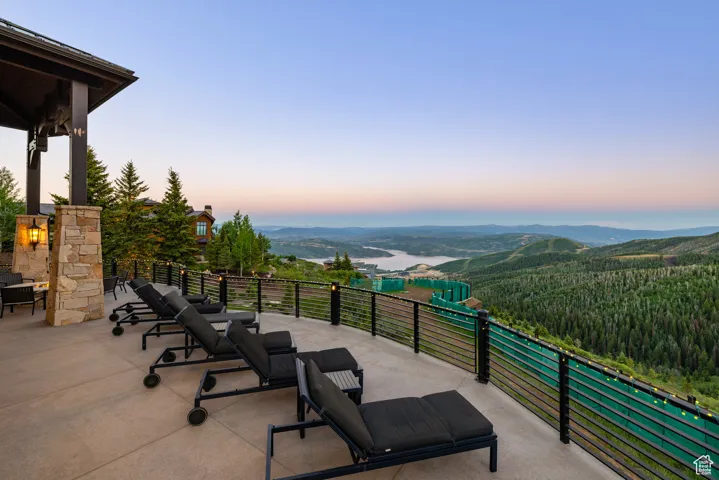 Patio terrace at dusk with a patio area and a wooded view