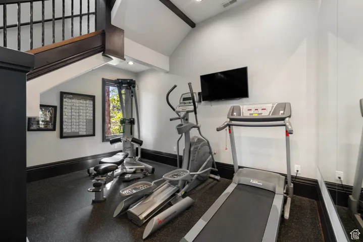 Workout room with lofted ceiling and recessed lighting