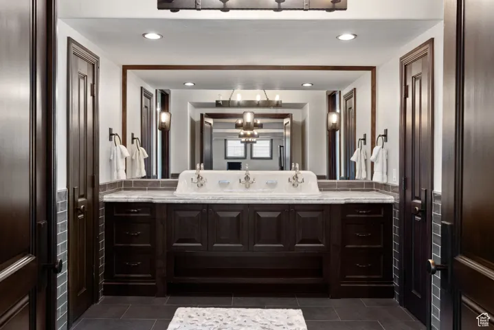 Bathroom featuring vanity, recessed lighting, and dark tile patterned flooring