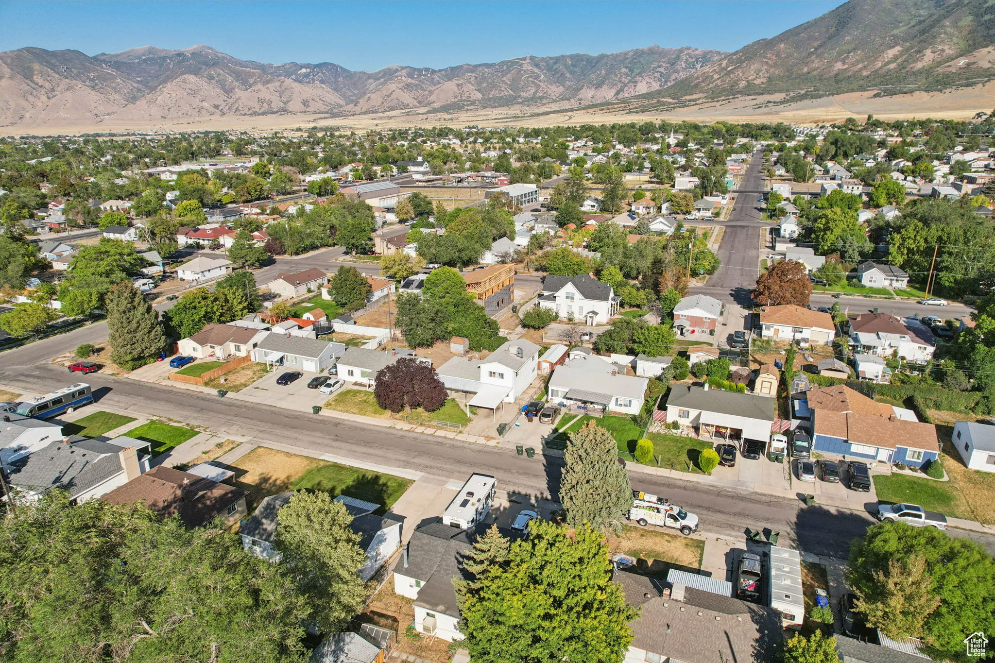 Aerial view of property's location with nearby suburban area and a mountainous background