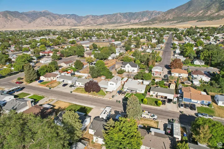 Aerial view of property's location with nearby suburban area and a mountainous background