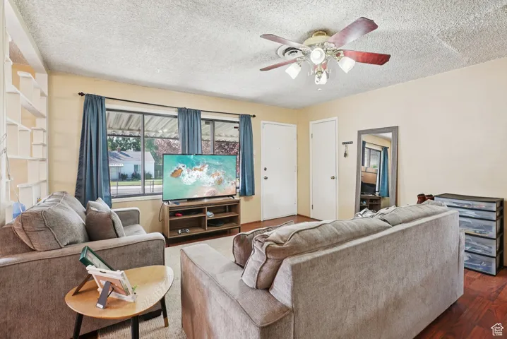 Living area with wood finished floors, a textured ceiling, and a ceiling fan