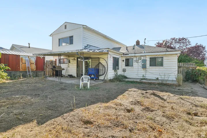 Rear view of house with a patio, a fenced backyard, and a chimney