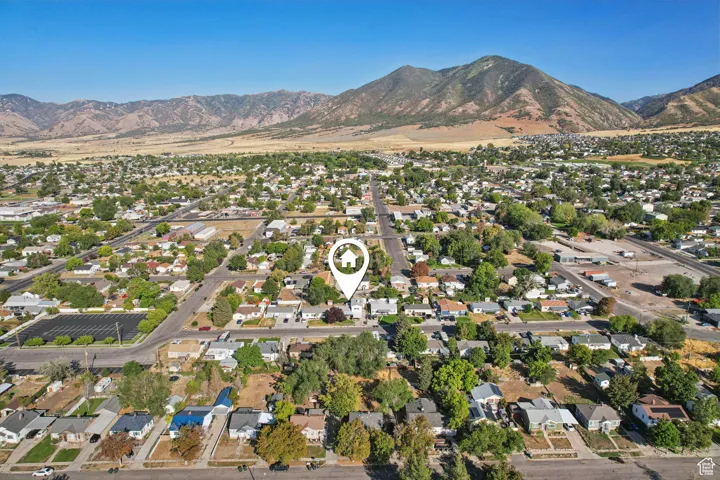 Aerial view of property's location featuring nearby suburban area and a mountainous background