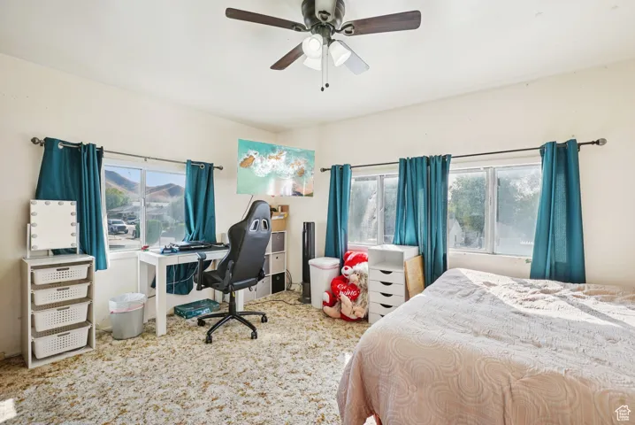 Bedroom featuring a desk, ceiling fan, and carpet floors