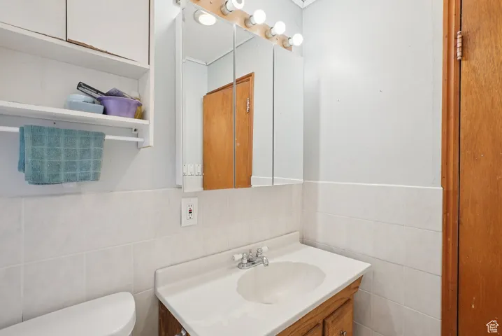 Bathroom featuring vanity and tile walls