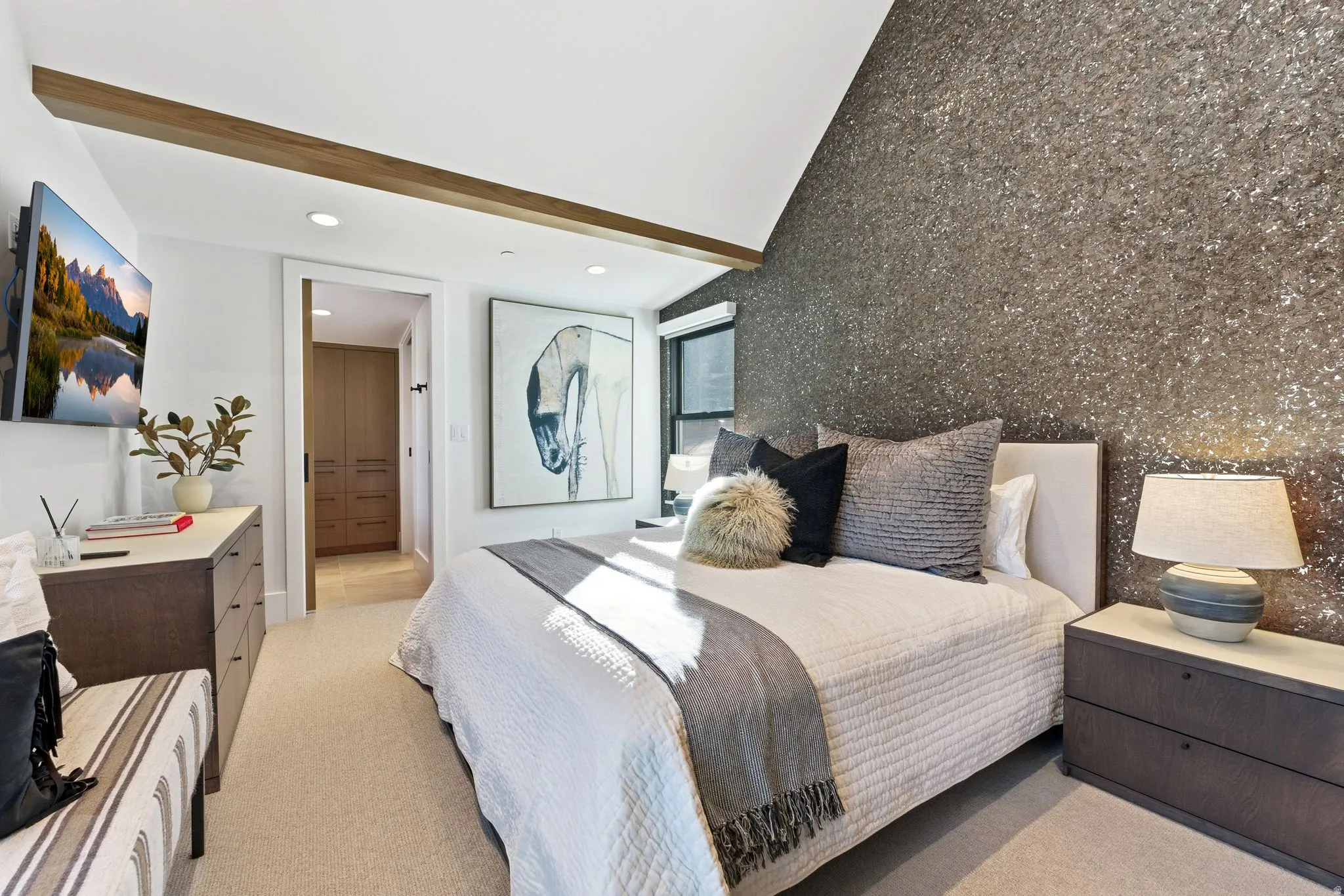 Bedroom with an accent wall, light colored carpet, recessed lighting, and beamed ceiling