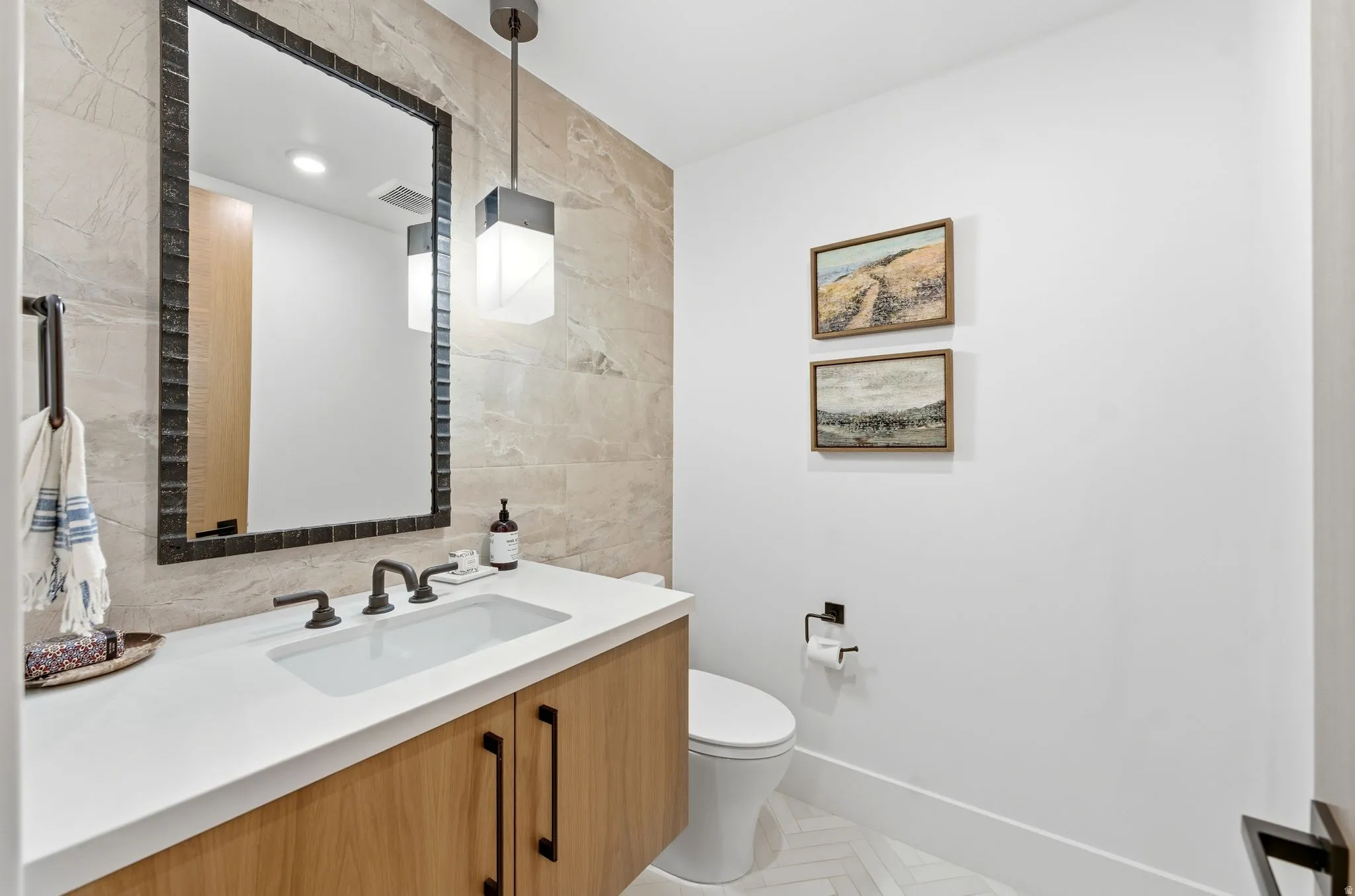 Half bathroom featuring tile walls and vanity
