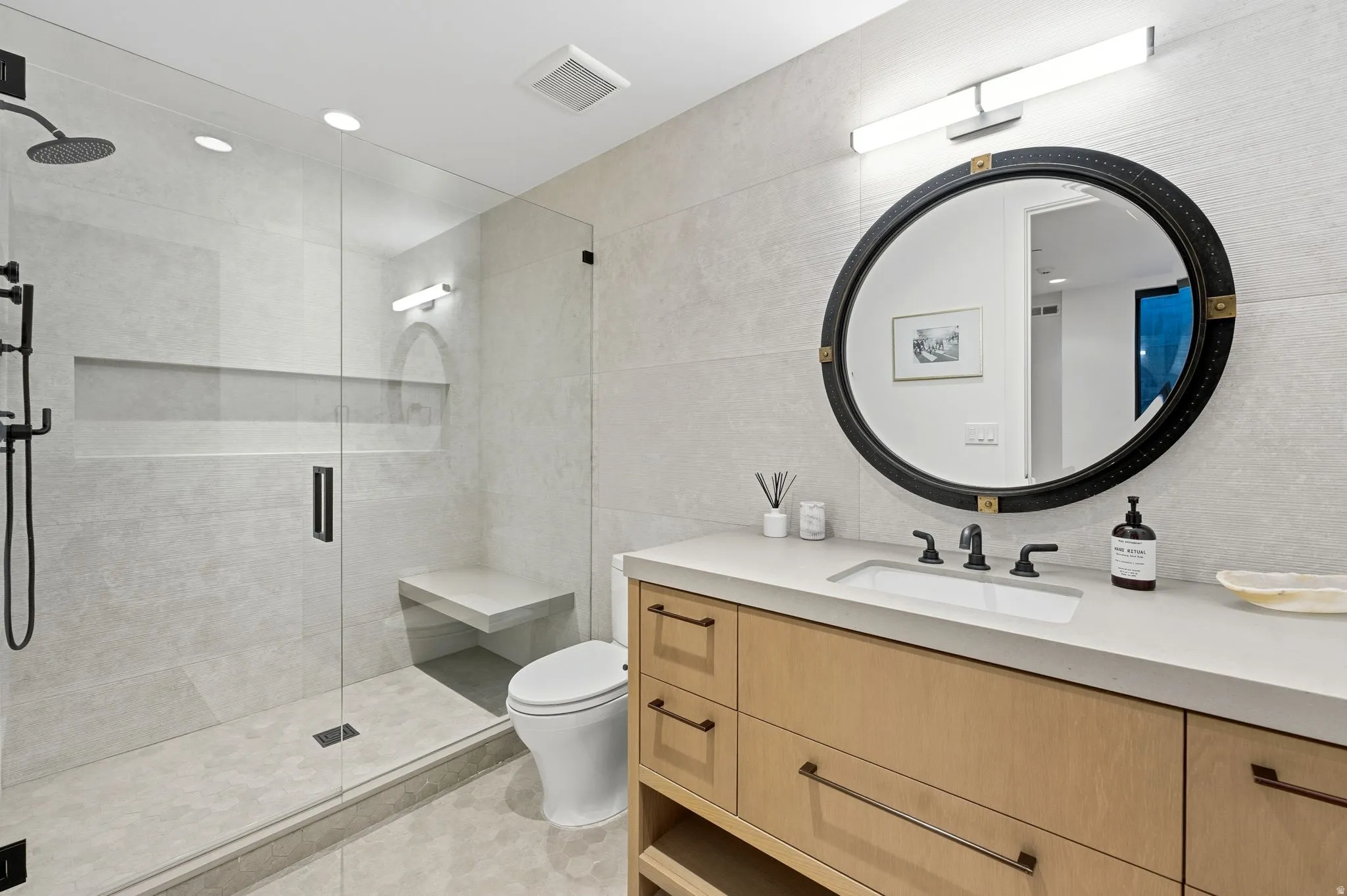 Full bath featuring vanity, a stall shower, tile walls, recessed lighting, and light tile patterned flooring