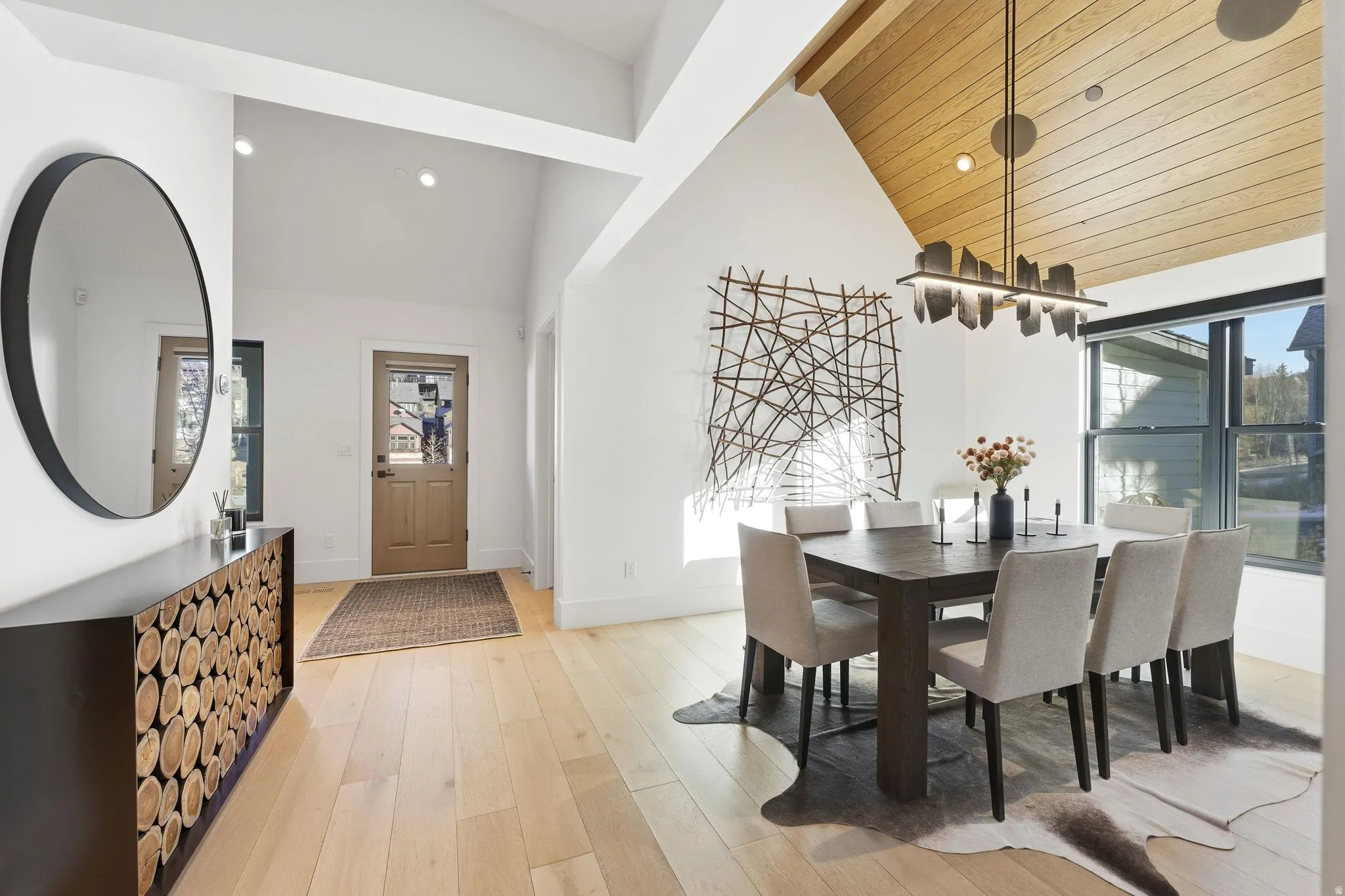 Dining room with light wood-style flooring, vaulted ceiling, recessed lighting, and a chandelier