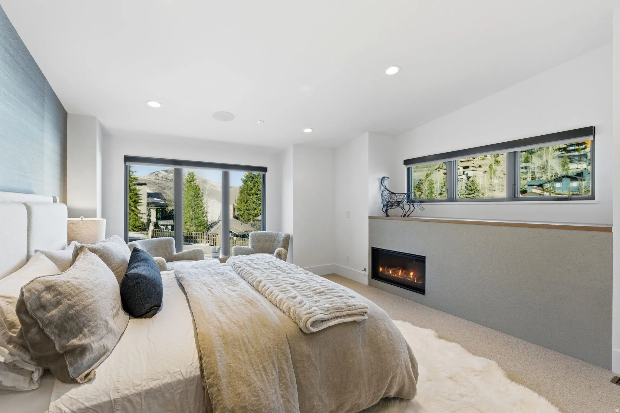 Bedroom with carpet flooring, a glass covered fireplace, multiple windows, access to outside, and recessed lighting