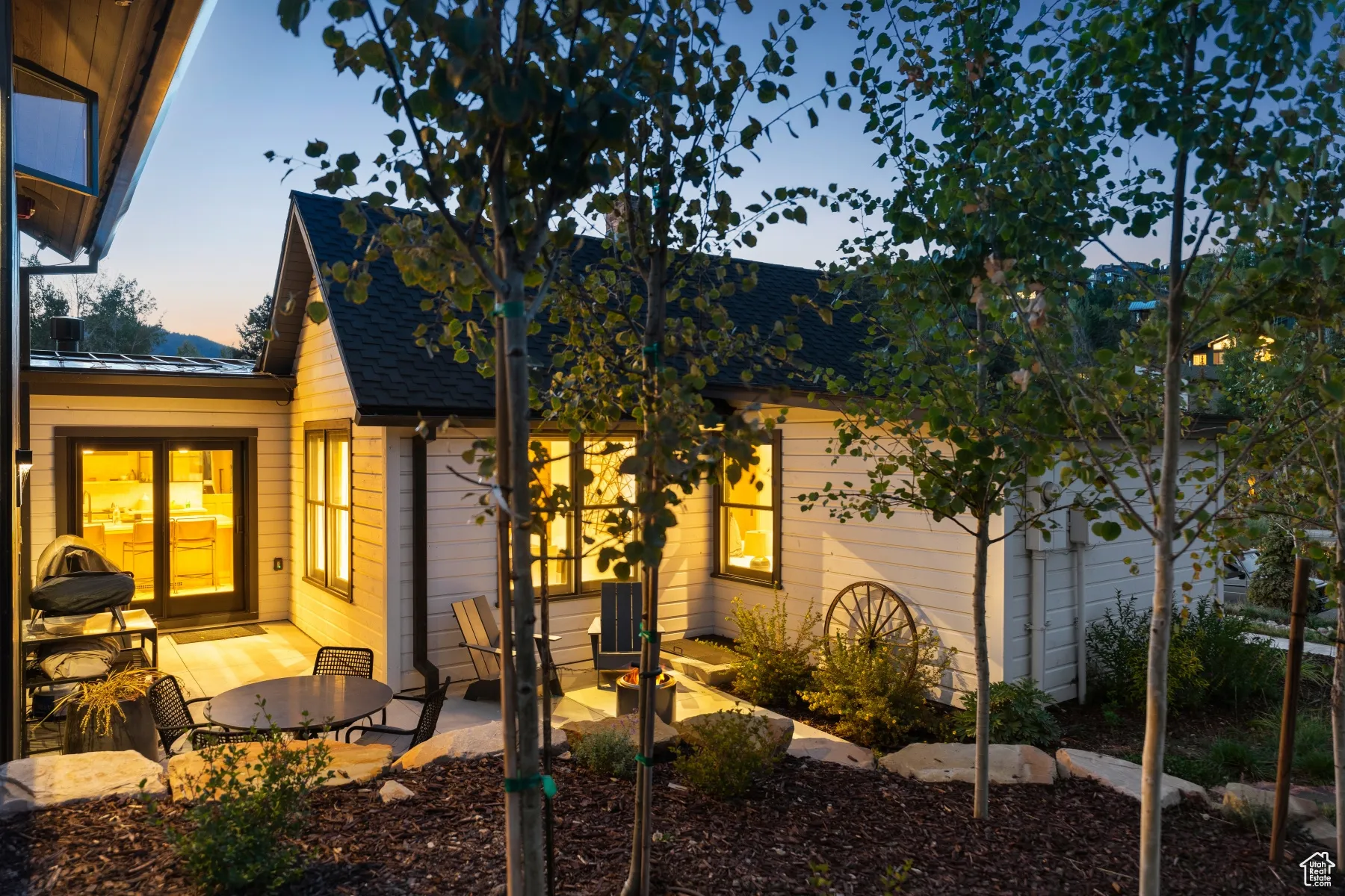 View of front of property with a standing seam roof, a metal roof, a patio area, and roof with shingles