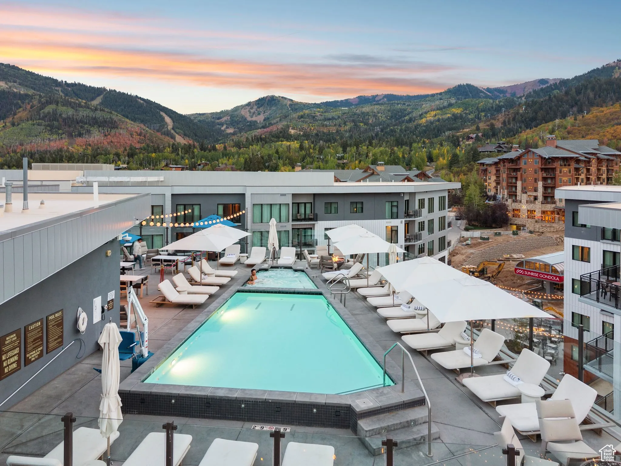 Pool at dusk featuring a mountain view, a community pool, and a patio