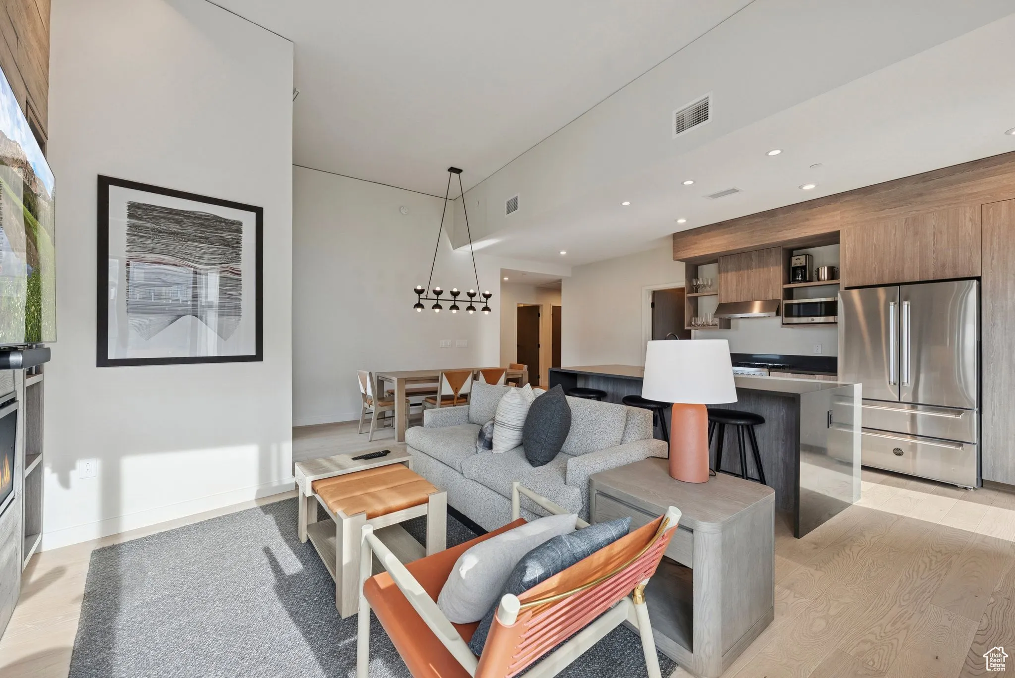 Living room with light wood-style flooring and recessed lighting