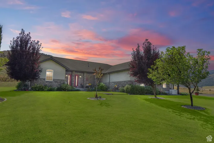 View of front of house with a front yard and stone siding