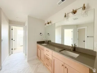 Bathroom featuring double vanity and baseboards