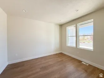 Spare room featuring dark wood-style floors, a textured ceiling, and recessed lighting