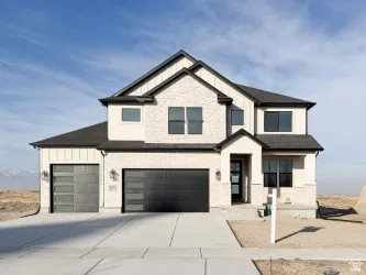 View of front of house with board and batten siding, driveway, and a garage