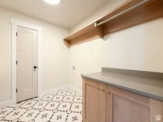 Washroom with light flooring, hookup for a washing machine, and cabinet space