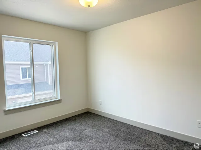 bedroom featuring baseboards and dark carpet