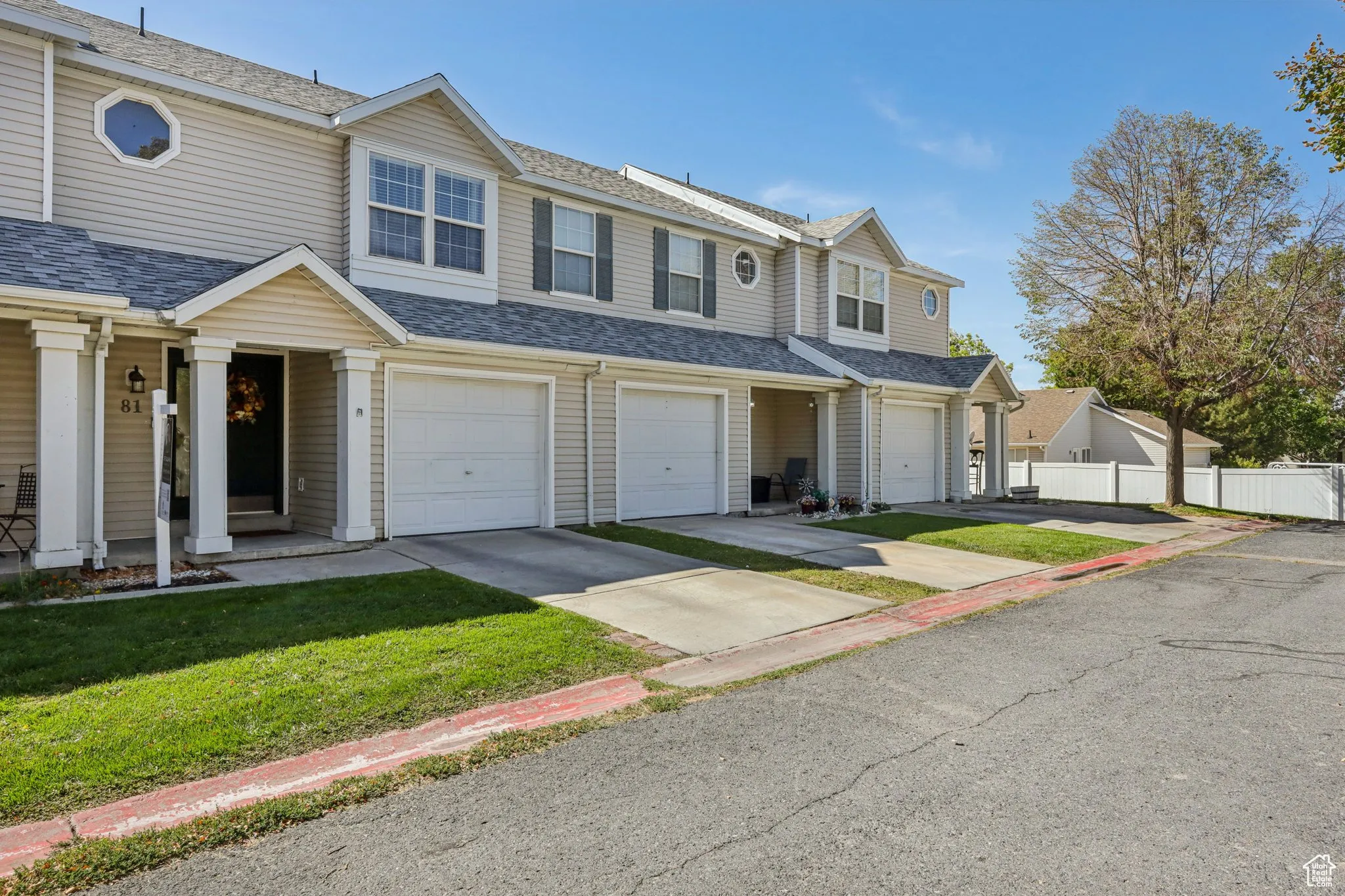 Traditional home featuring a shingled roof, concrete driveway, a residential view, and a garage