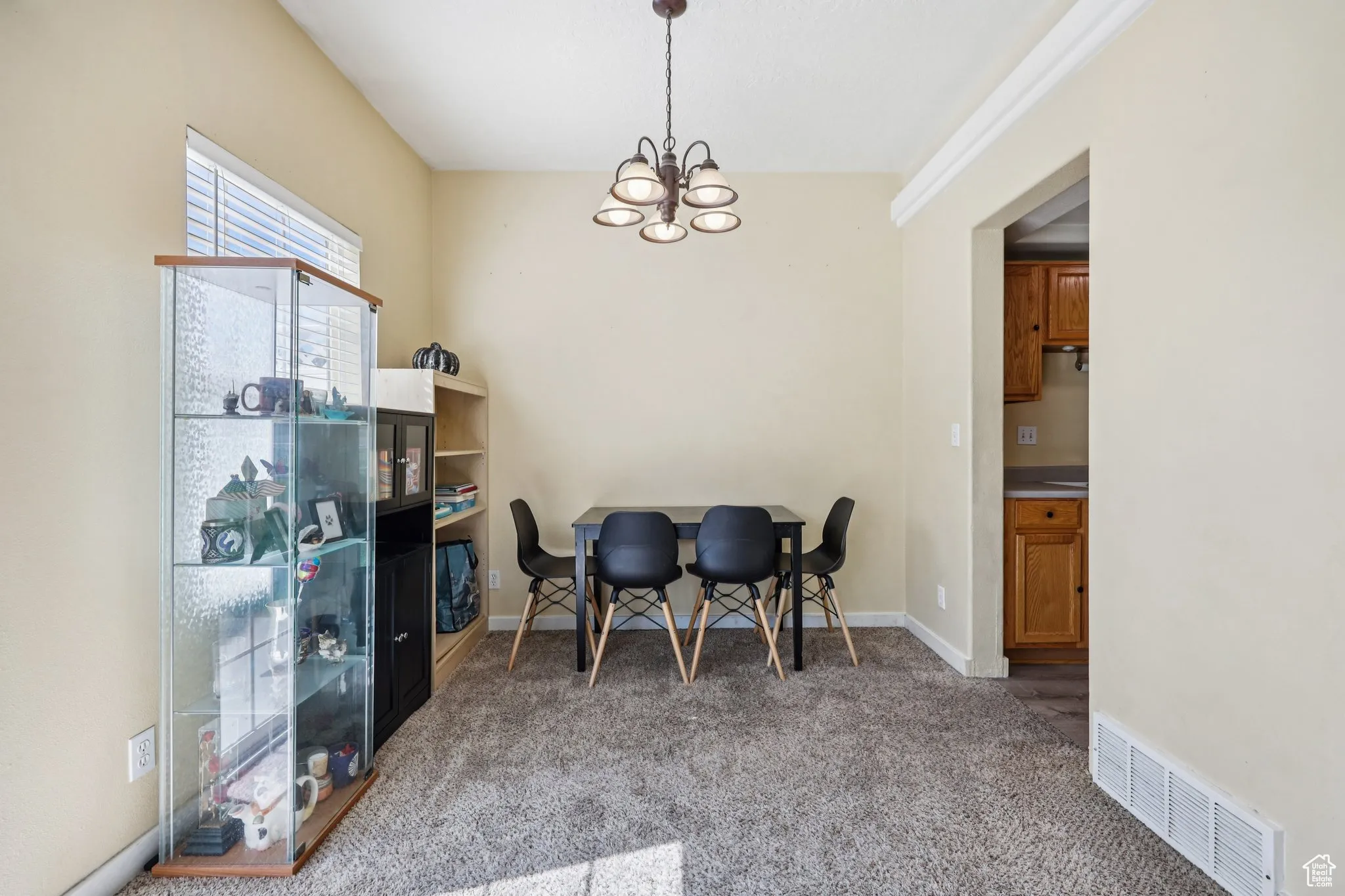 Dining room with light colored carpet and a chandelier
