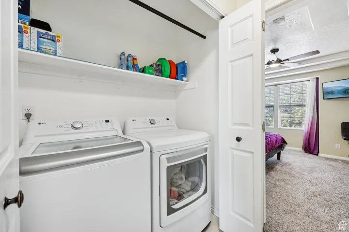 Washroom with light colored carpet, a textured ceiling, ceiling fan, and separate washer and dryer