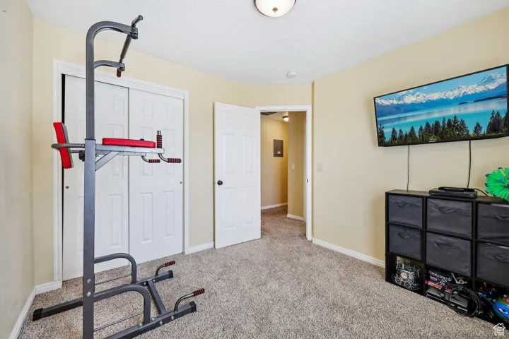 Workout area featuring baseboards and carpet flooring