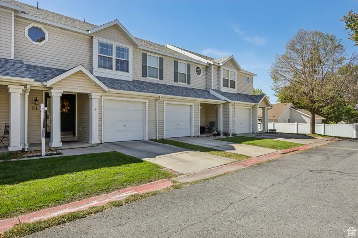 Traditional home featuring a shingled roof, concrete driveway, a residential view, and a garage