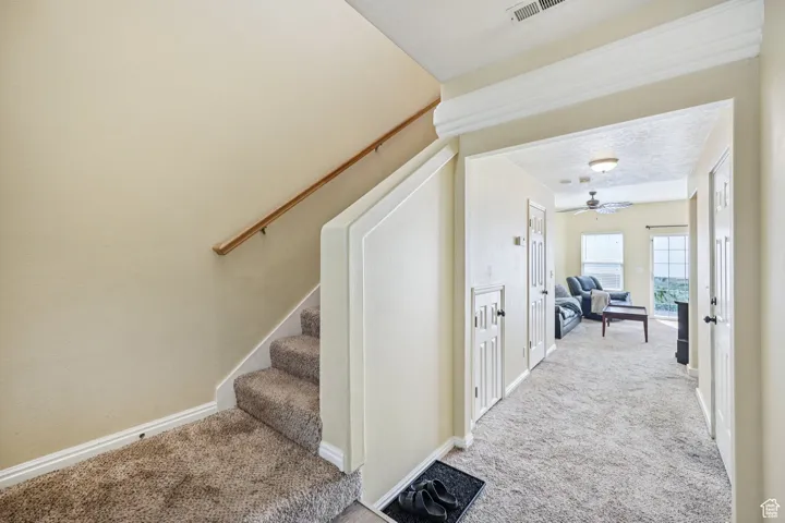 Stairway with carpet flooring and ceiling fan