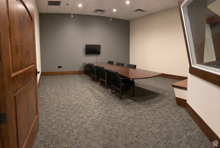 Home office featuring a paneled ceiling, dark colored carpet, and recessed lighting