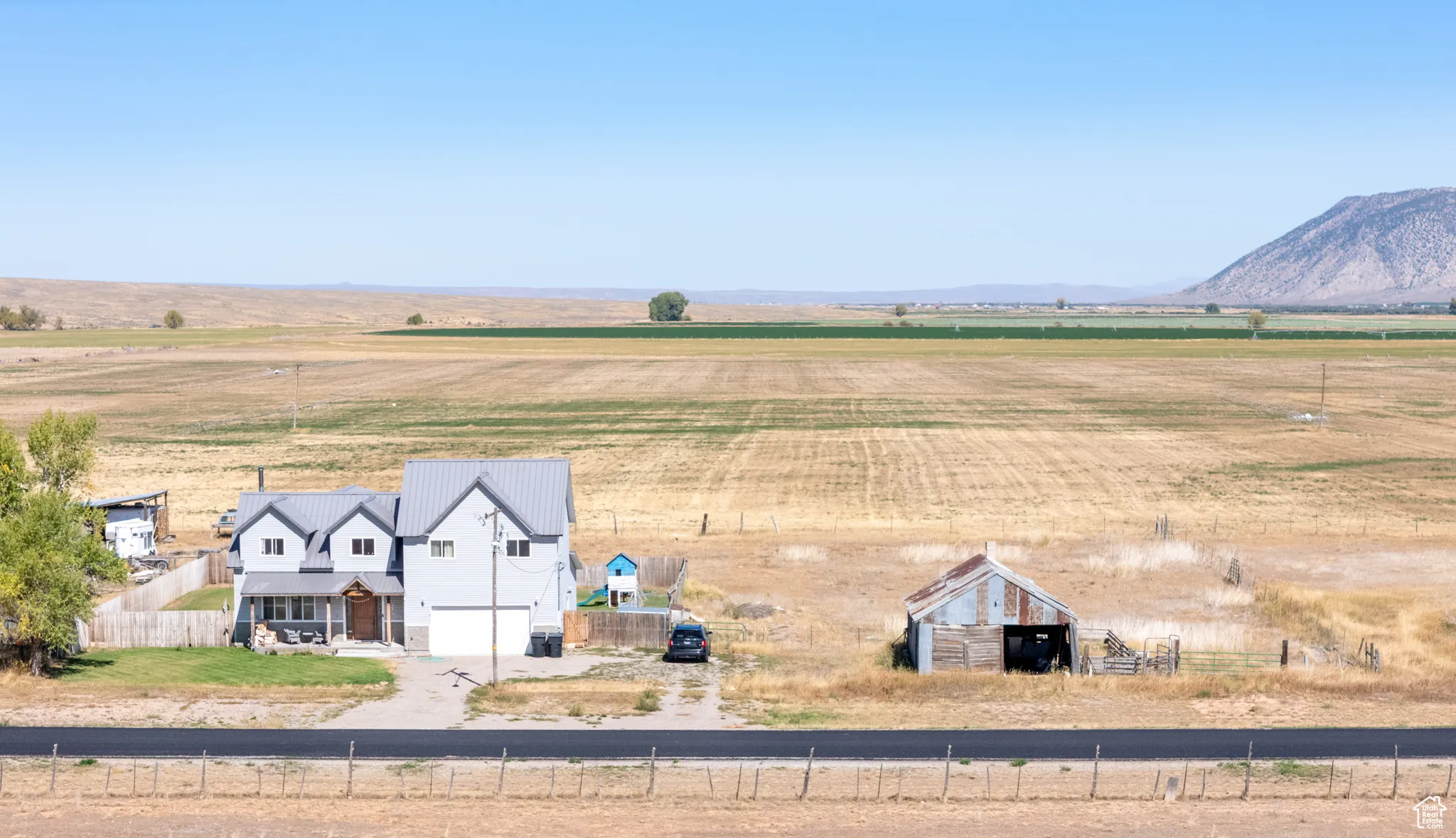 View of rural area with large plots for crops and a mountainous background