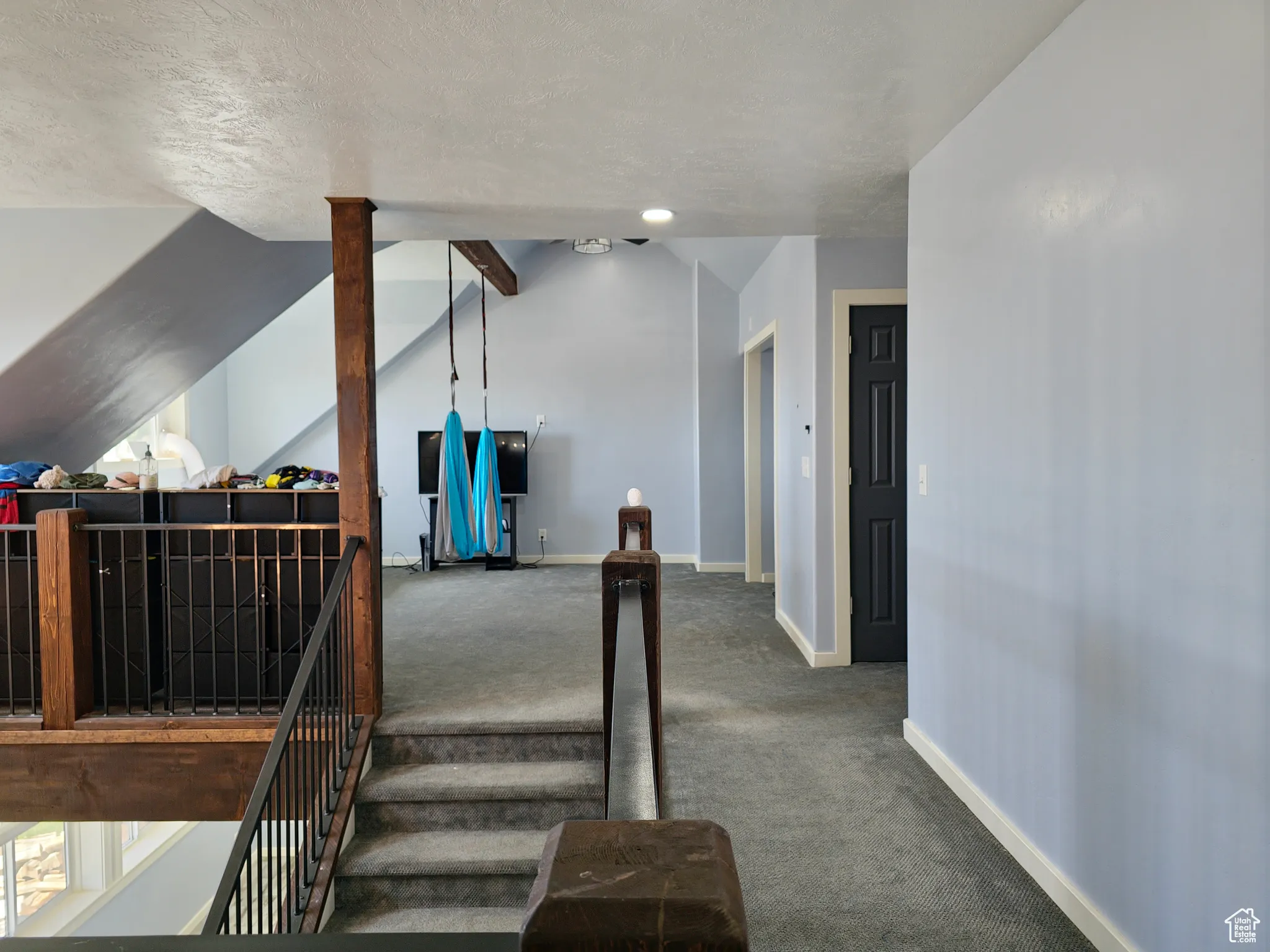 Stairs with lofted ceiling, carpet, and a textured ceiling