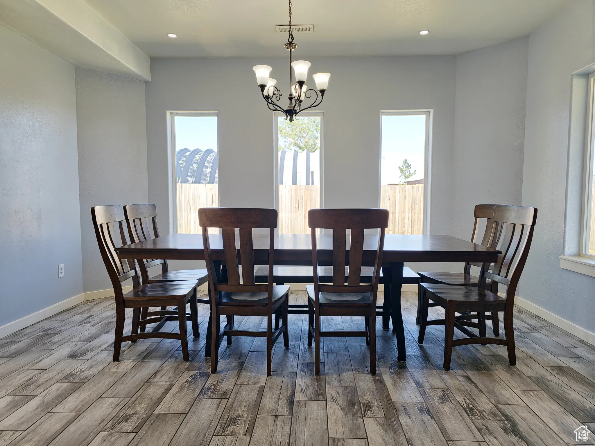Dining area featuring light wood-style floors, recessed lighting, and a chandelier