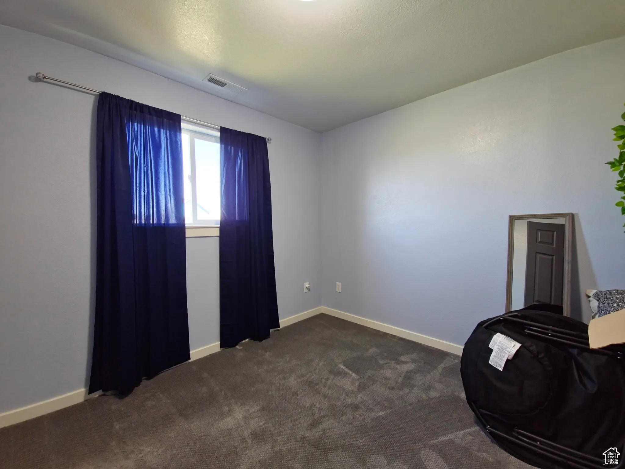 Sitting room with dark carpet and baseboards