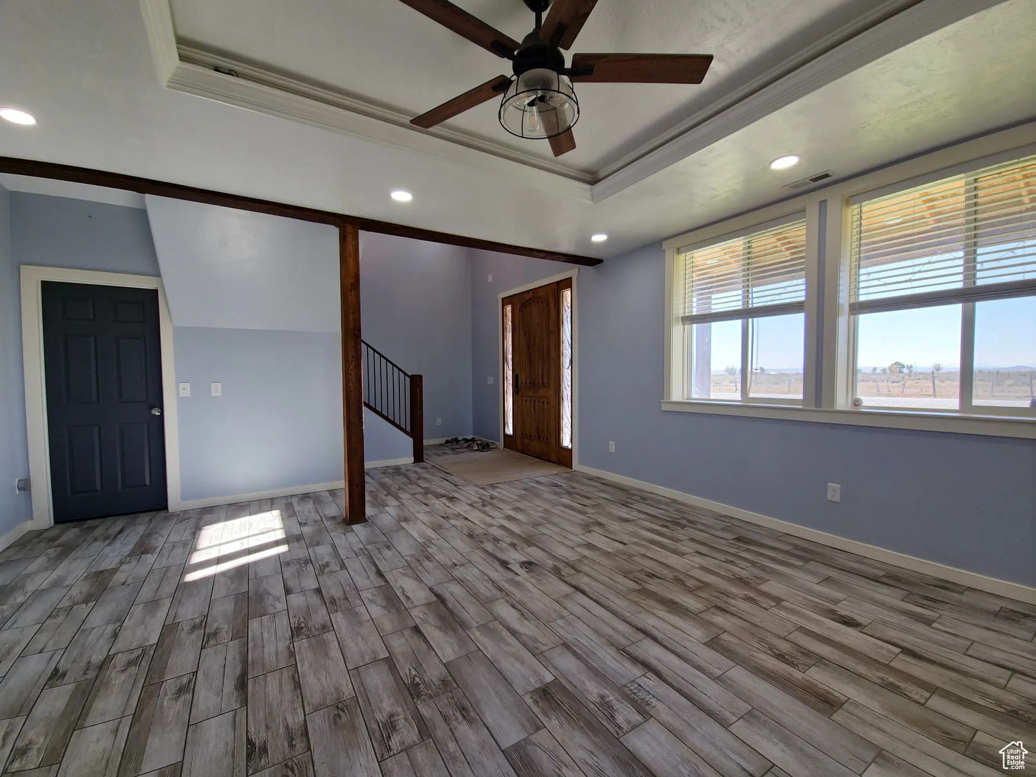 Spare room featuring recessed lighting, a tray ceiling, wood tiled floors, crown molding, and a ceiling fan