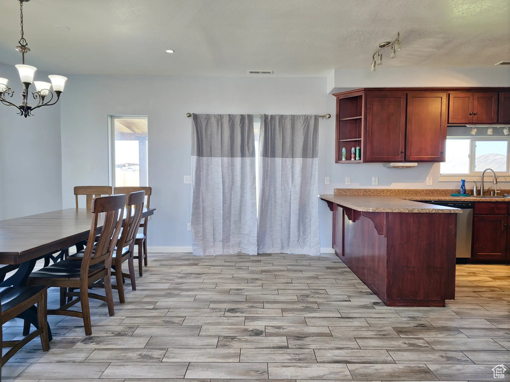 Kitchen with healthy amount of natural light, open shelves, a breakfast bar, and light wood finished floors