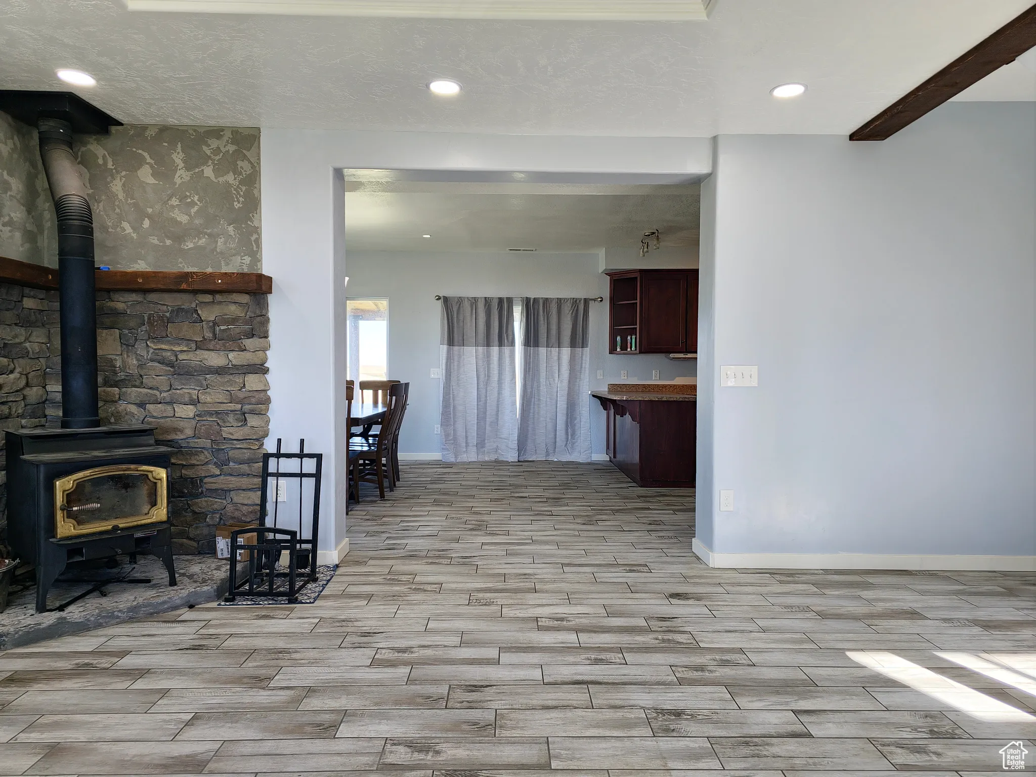 Living room featuring a wood stove, wood tiled floors, recessed lighting, and a textured ceiling