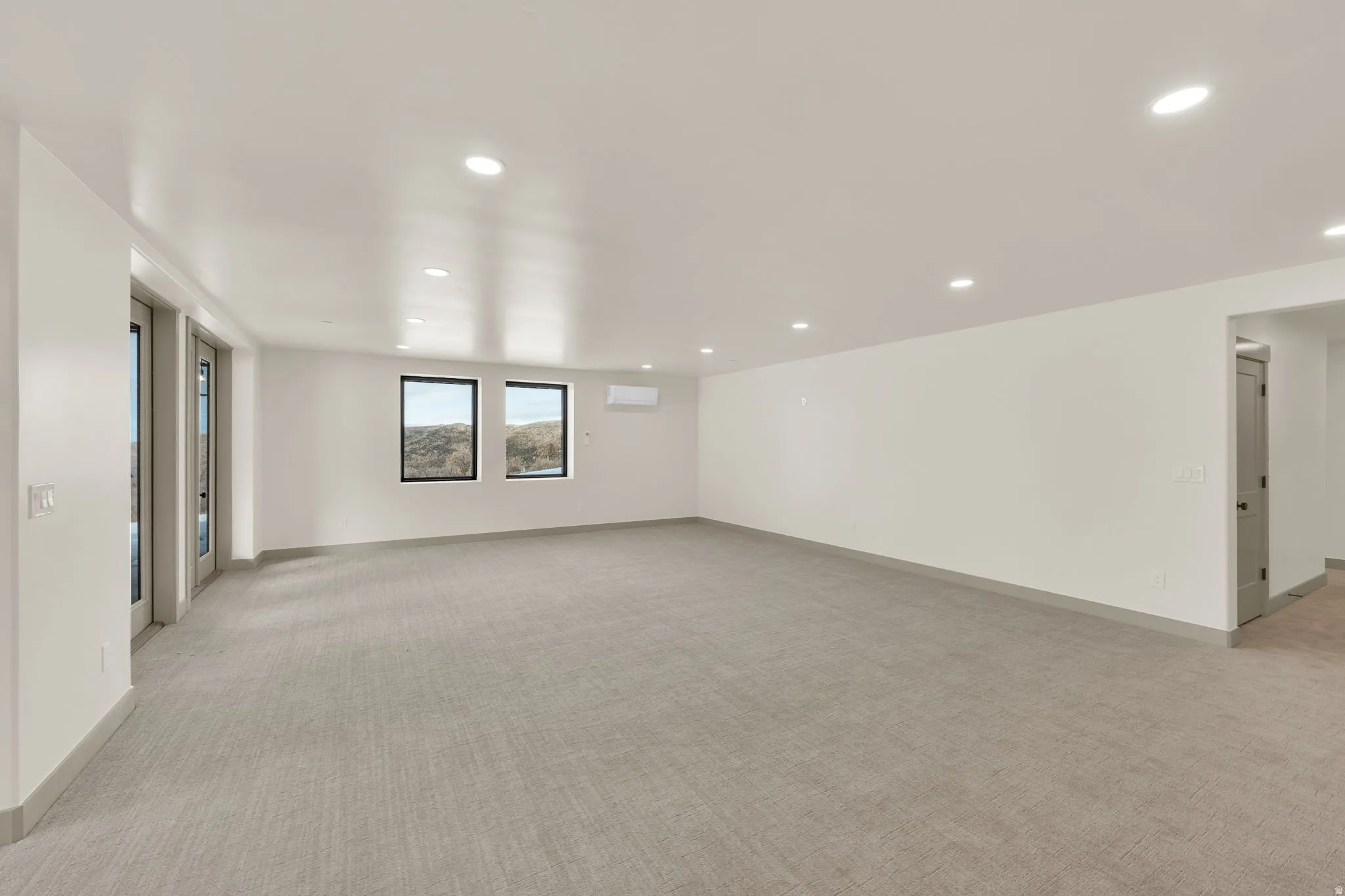Daylight basement recreation room with French doors leading to patios and hot tub area.