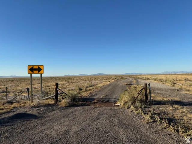 View of dirt / gravel road featuring a view of countryside and a mountain view
