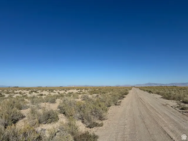 View of dirt / gravel road featuring a view of countryside, a mountain view, and view of desert landscape