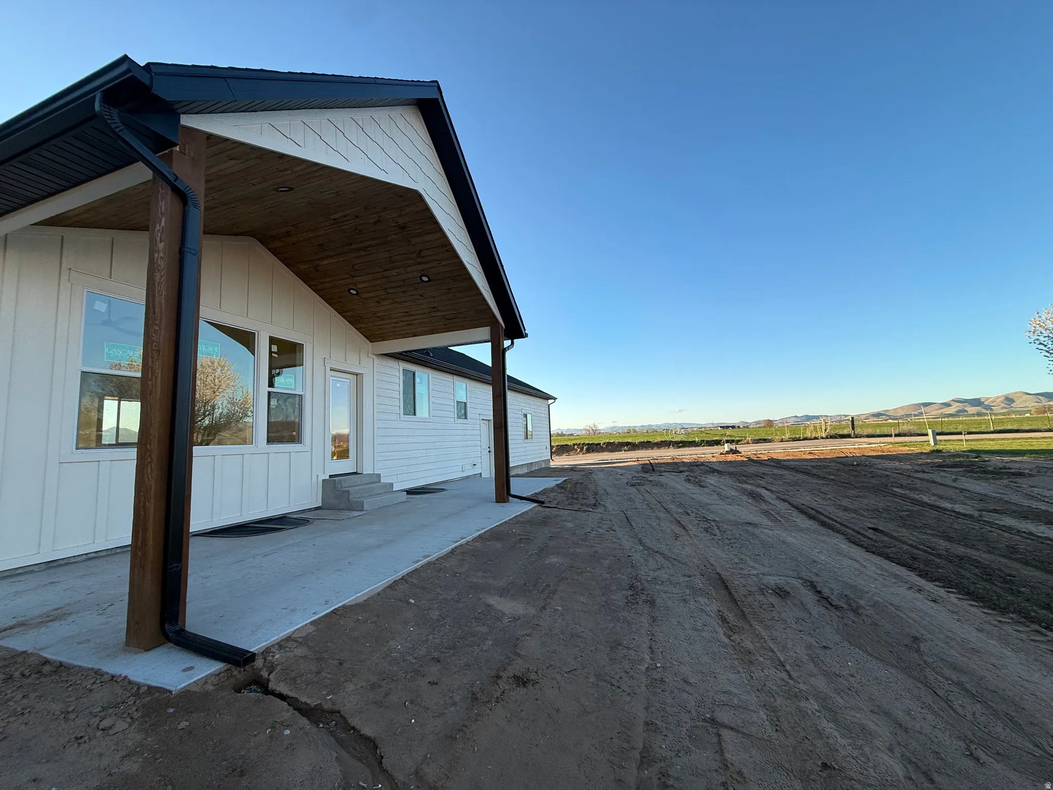 View of side of property featuring a patio area, board and batten siding, entry steps, and a mountain view