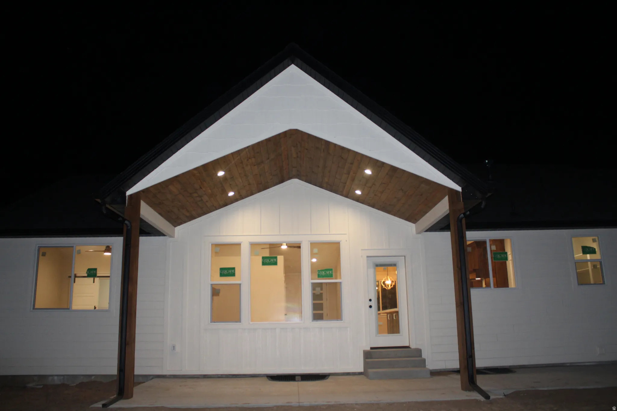 View of front of house with a patio area, entry steps, and board and batten siding