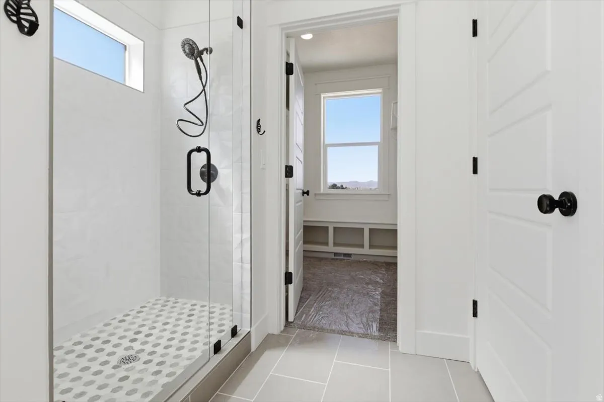 Full bath with a shower stall, plenty of natural light, and light tile patterned floors