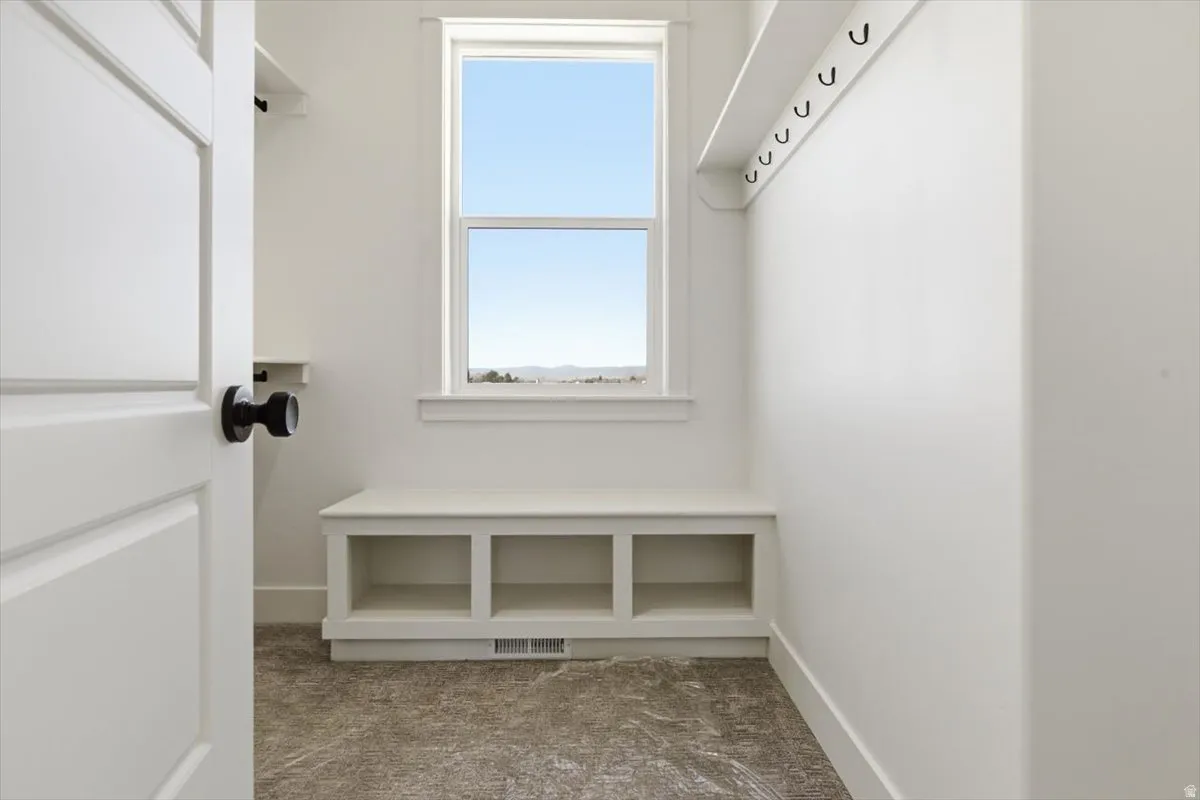Mudroom featuring carpet and baseboards
