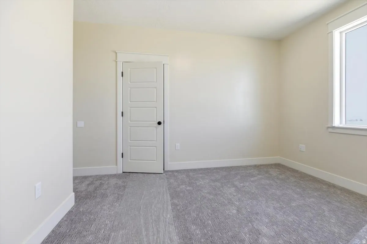 Carpeted empty room with baseboards