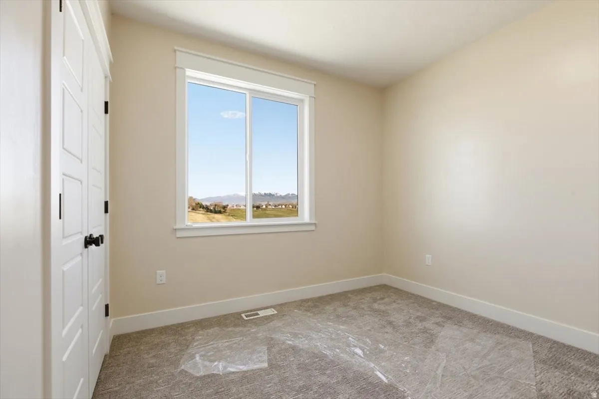 Unfurnished bedroom with light colored carpet and a closet